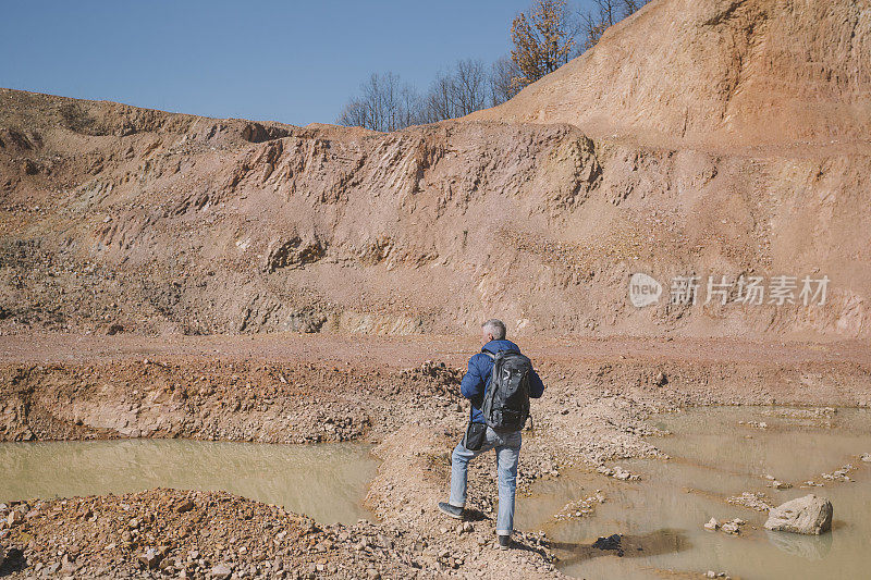 一名成年徒步旅行者参观了满是大水坑的石灰岩采石场