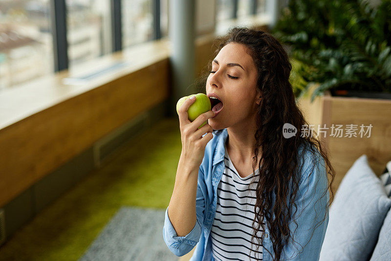 女商人吃健康零食，上班时吃苹果