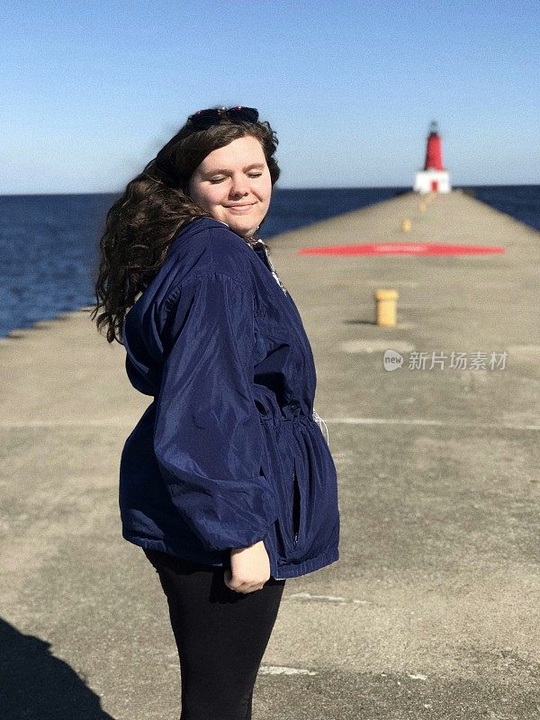 可爱的年轻女子探索密西根上半岛的灯塔码头在安阿伯公园在梅诺米尼。