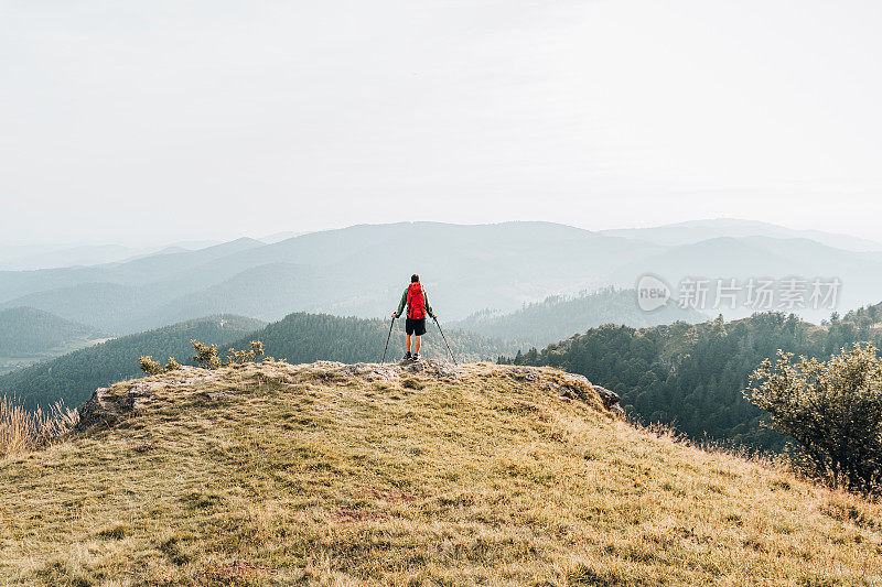 徒步旅行者在长满草的山脊上放松的观点