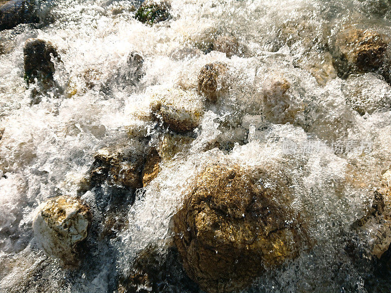 水在山上汹涌的河流。美丽的石头和水的自然背景。清澈的河水和湍急的河水。背景以插入文本。旅游和旅行。