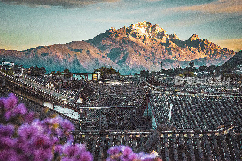 在中国丽江大雁古镇玉龙雪山的屋顶上看日出
