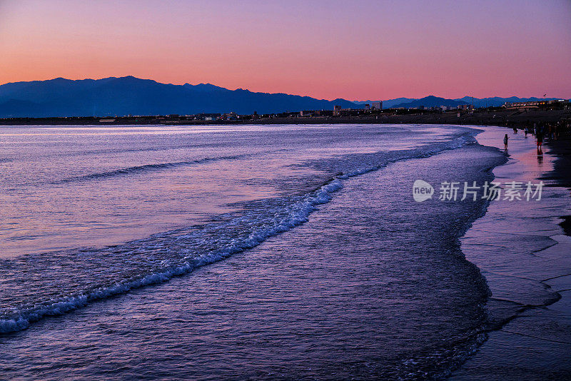 日落时，海滩上的剪影山映衬着天空