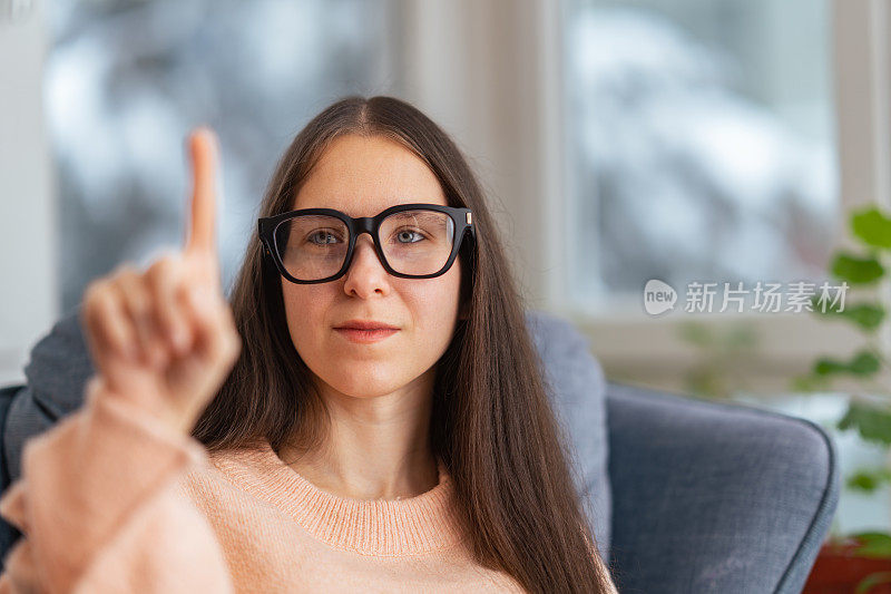 美丽的女商人坐在沙发上的肖像和使用智能眼镜。元境智能眼镜虚拟现实技术概念