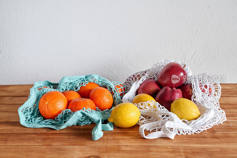 橙子，柠檬和苹果放在可重复使用的袋子里