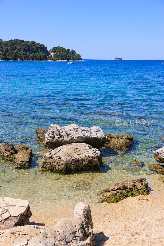 蓝色海景从遥远的位置上看到岩石海岸线与沙滩上的沙子