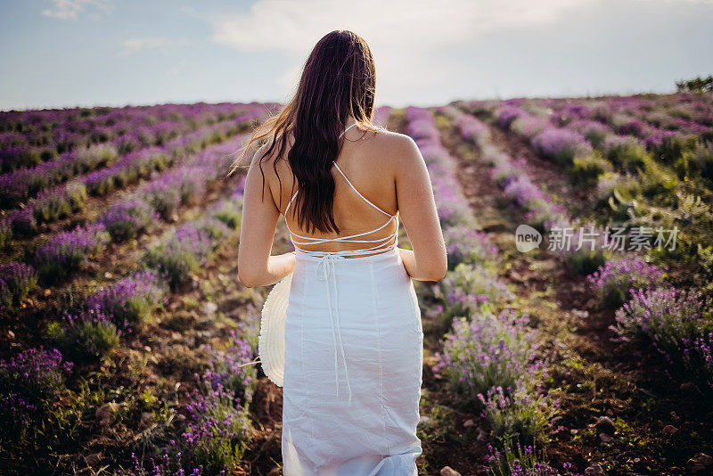 一个戴着帽子的漂亮年轻女孩的背影