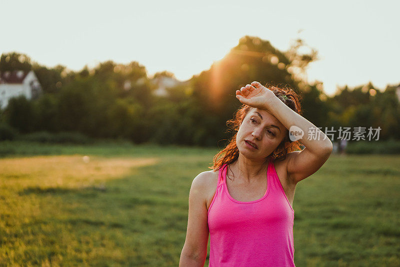 在自然公园里，一名女子在日出后跑步和锻炼后筋疲力尽