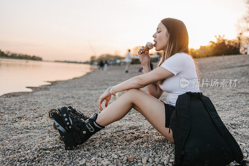 穿着溜冰鞋背着背包吃冰淇淋的女人