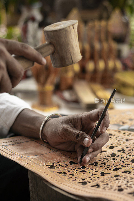 工艺艺术家在印度尼西亚制作传统的水牛皮革雕刻艺术