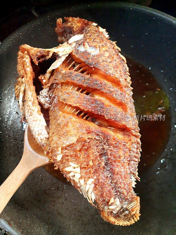 炒制罗非鱼的平底锅食品准备。
