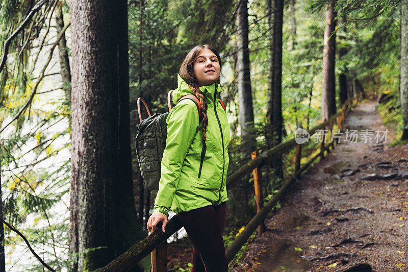 背着双肩包的女人在风景优美的森林里思考秋天的一天