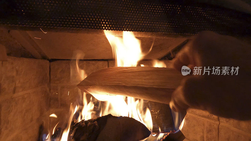 潘把木头放进壁炉里烧