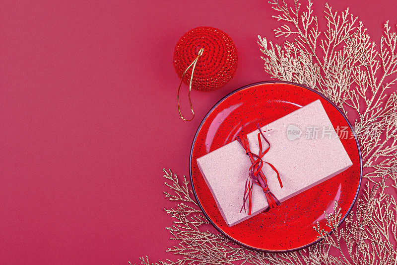 圣诞餐桌设置与节日礼盒新潮Viva品红色的背景。新的一年