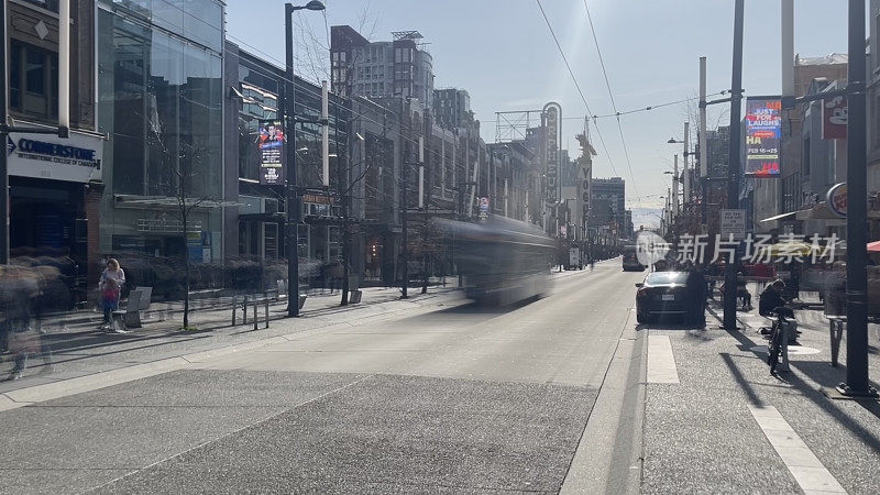 温哥华市中心的Granville街的快门时间很长，所以在3月的一个阳光明媚的日子里，人们和汽车的运动都有广告