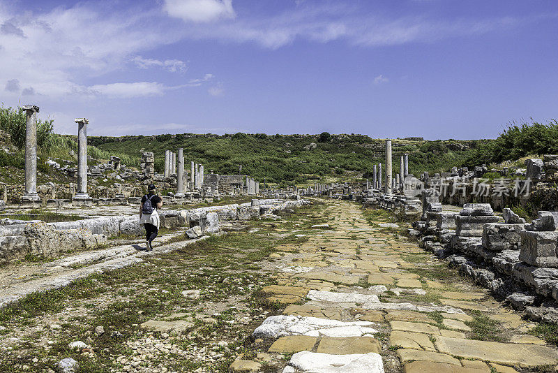 一名游客走在佩尔热古城的废墟中。公元前7世纪的希腊殖民地，公元前334年被波斯人和亚历山大大帝征服。安塔利亚土耳其。