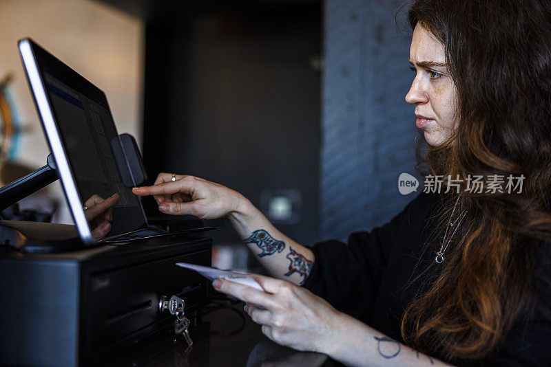 在咖啡馆收银机更新:困惑的妇女计算现金，处理付款-敲击电脑屏幕在咖啡馆或餐馆收银机兑现程序
