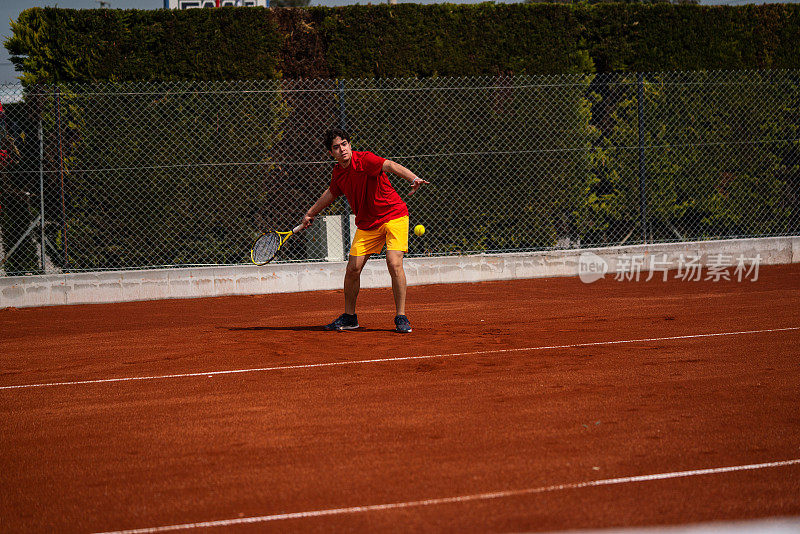 男子网球运动员仍在红土场上正手击球