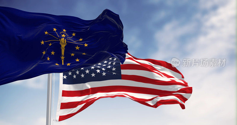 在一个晴朗的日子里，印第安纳州的国旗与美国国旗飘扬在一起
