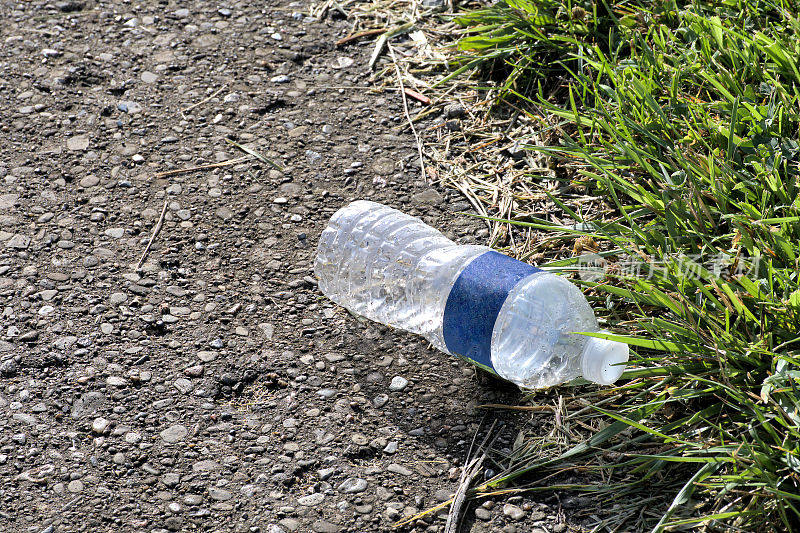 混凝土路上的一次性塑料水瓶。