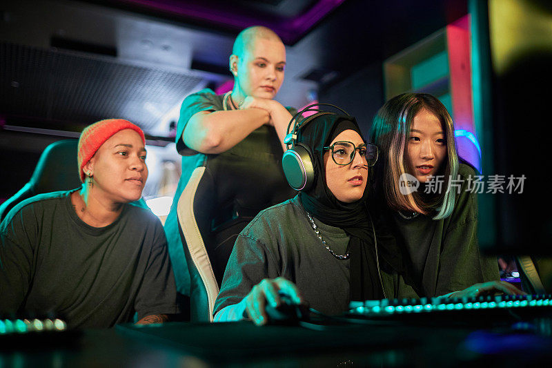 穆斯林年轻女子在电子竞技俱乐部与不同的团队玩电子游戏