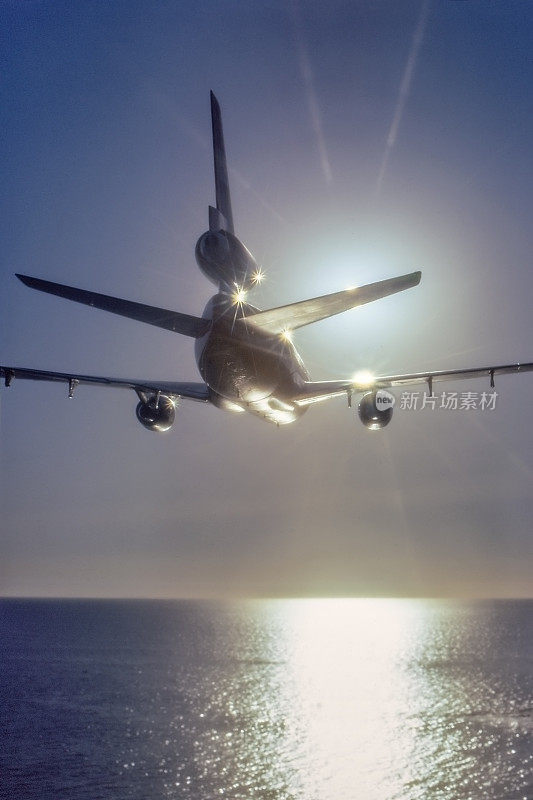 DC-10飞机飞向夕阳的后视图