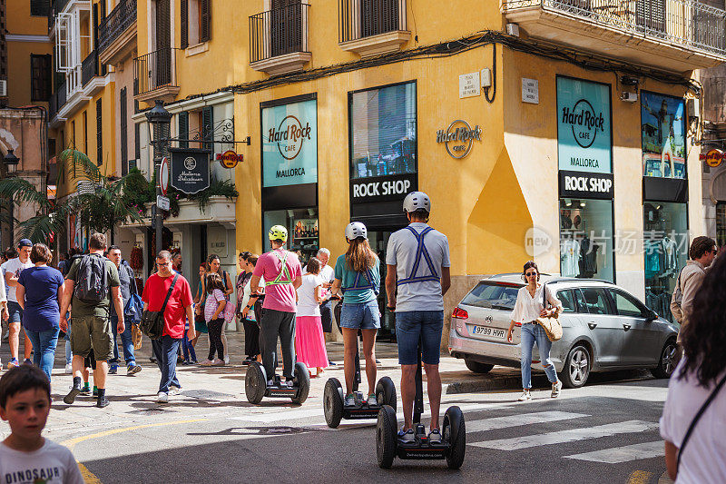 游客们正在使用赛格威在街道上穿梭，探索帕尔马德马略卡市