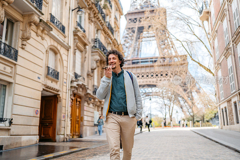 法国巴黎，一个年轻人在埃菲尔铁塔前发语音信息