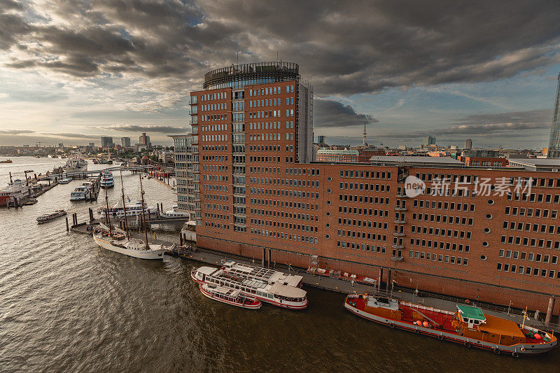 汉堡港城区的Speicherstadt。德国风景，德国旅行摄影。易北河与商业码头的照片。夕阳和天空，傍晚的好天气。港口的船只和建筑。