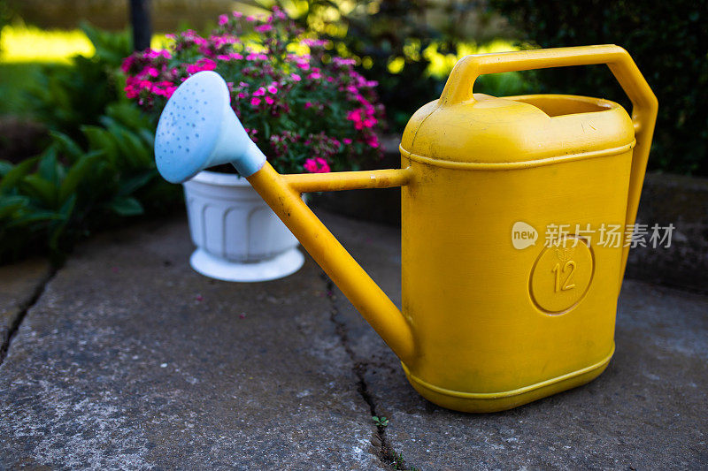 一个黄色的塑料喷壶在后院