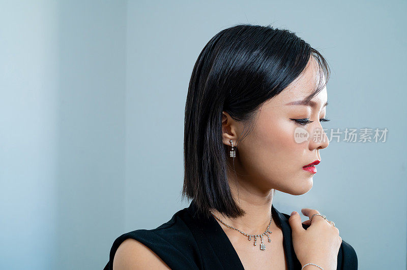 美丽的亚洲女人的肖像穿着一套时髦的珠宝，钻石戒指，项链，手镯和耳环