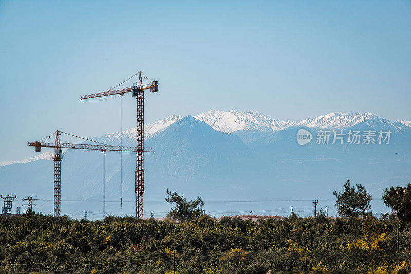 以雪山为背景的大型建筑起重机