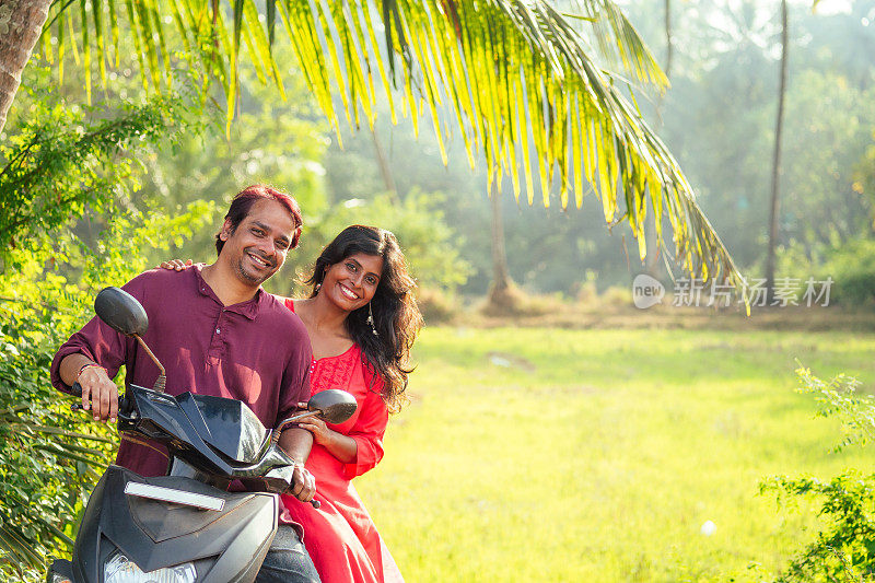 快乐的印度夫妇骑摩托车在印度果阿的热带丛林探险