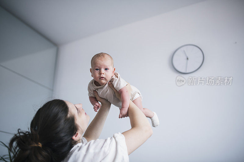 母亲在卧室里把男婴抛向空中。