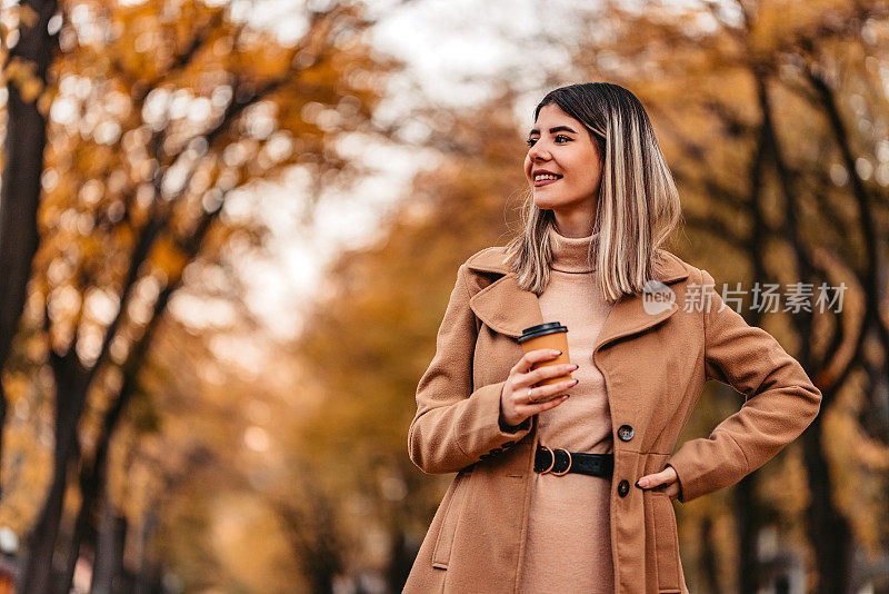 秋天在公园散步的年轻女子