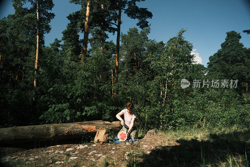 一个女人在自然公园里吃西瓜