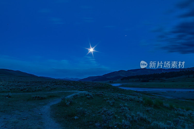 在美国怀俄明州西北部的黄石公园拉马尔山谷，夜幕降临后，月亮和木星明亮地照耀着
