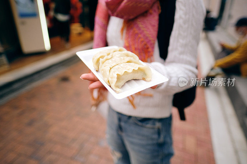 在街上展示饺子的妇女
