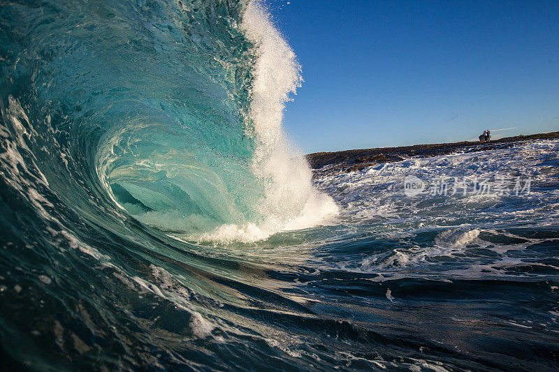 强大的蓝绿色波浪在岩石上爆炸
