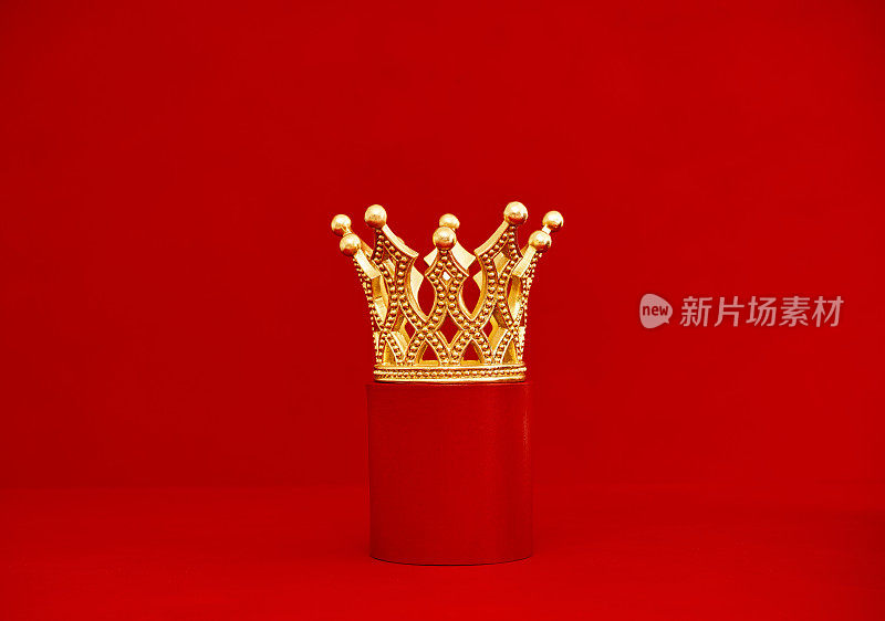 红色底座上装饰的金色皇冠。红色背景与复制空间