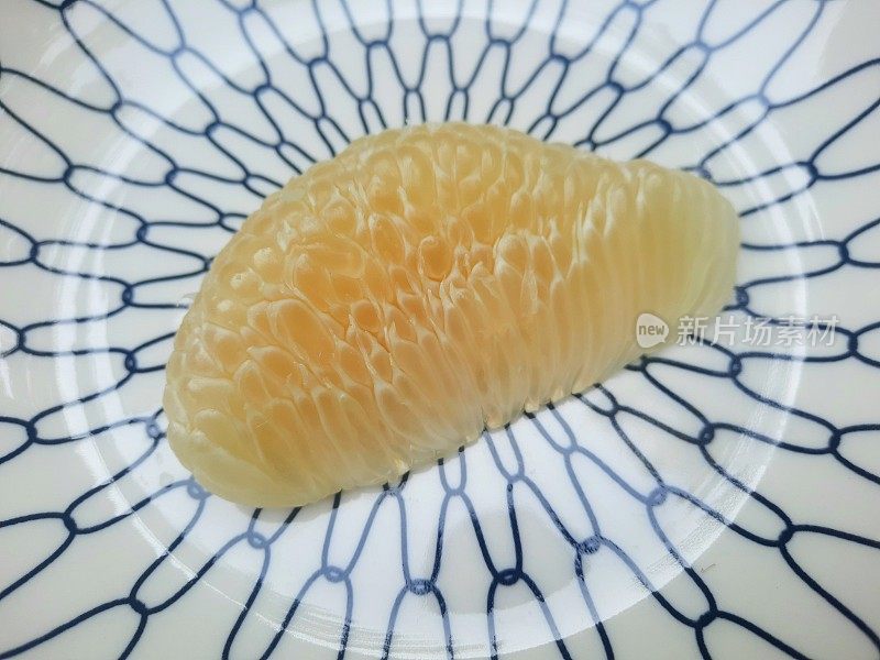 去皮柚子放在盘子里。