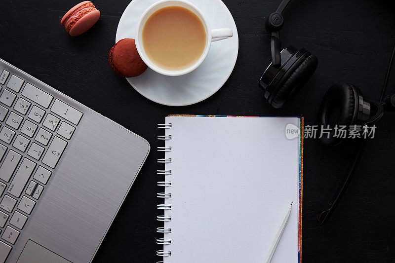 笔记本，笔记本，耳机，咖啡和杏仁饼干的模型。在线生活方式，参加网络研讨会，远程工作，学习，听音乐