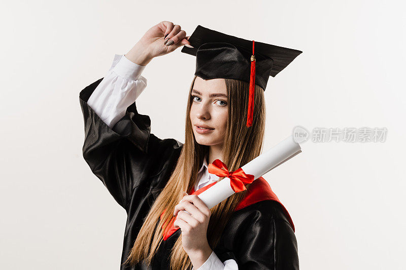 快乐的毕业女孩微笑着，手里拿着白色背景的荣誉证书。毕业典礼。女研究生从大学毕业并获得硕士学位。
