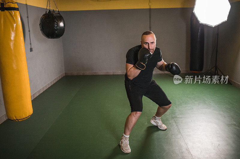 穿着运动服的男拳击手在健身房独自训练，为拳击比赛和锦标赛做准备