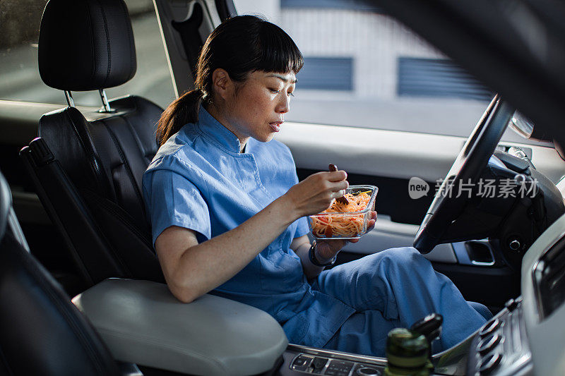 年轻的日本医护人员在车里吃午饭