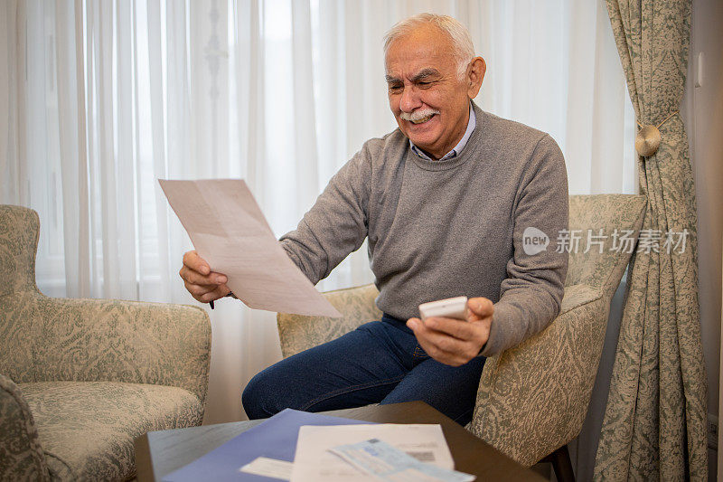 老人在处理账单和家庭财务时使用计算器