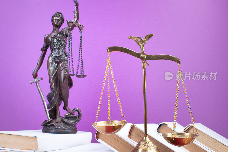 法律概念-打开法律书，法官的小木槌，天平，法庭或执法办公室桌子上的忒弥斯雕像。木桌，紫色背景。