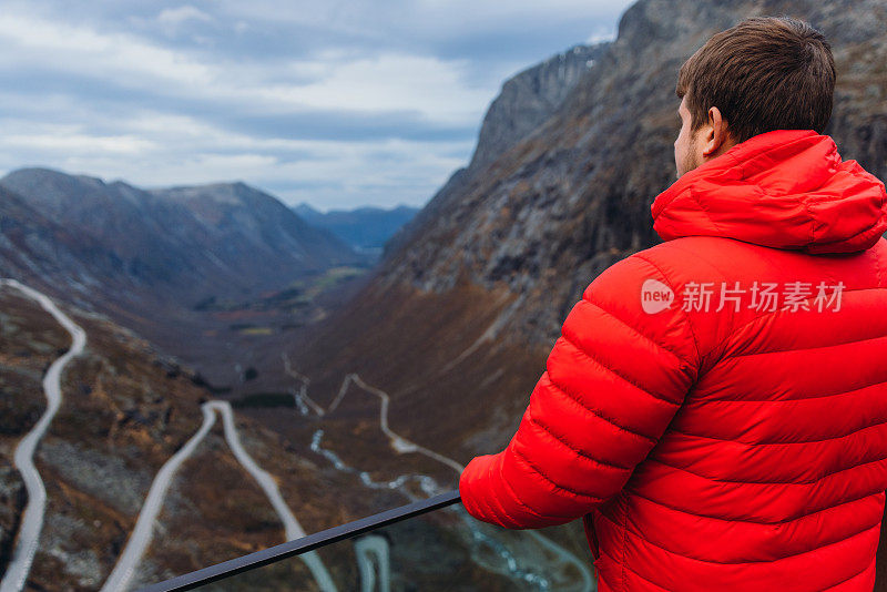 一名男子凝视着挪威特罗尔斯蒂根的发夹路田园诗般的景色