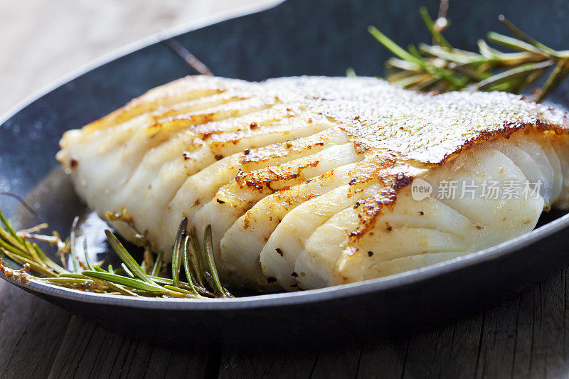鲜煎大西洋鳕鱼与迷迭香在煎锅中