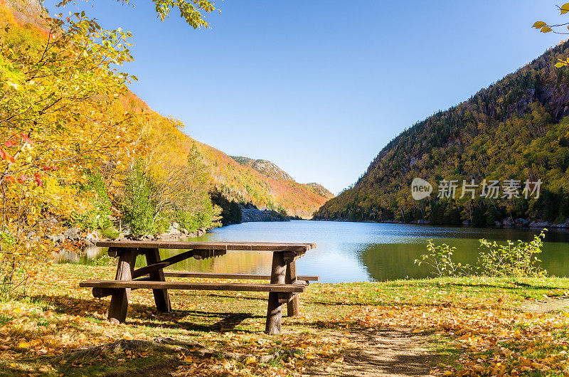 一个晴朗的秋日，山湖上的空野餐桌